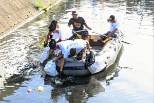 Tim Pembersih Sungai Menggunakan Perahu Karet Untuk Mengambil Sampah